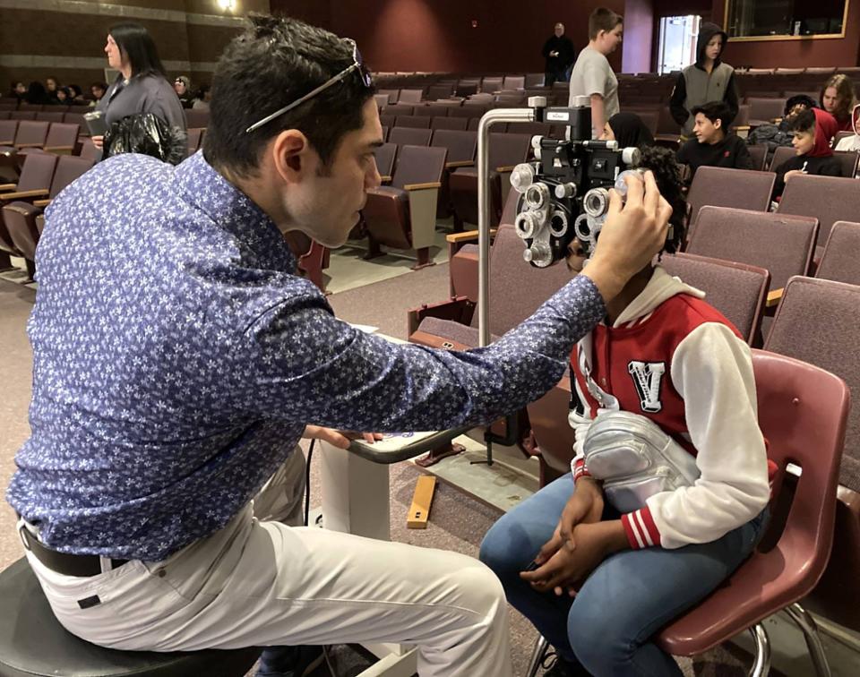 Vittorio Mena, an optometrist with Optical Academy, determines the prescription Ke'Zarria Wayne needs for her new glasses. Wayne, 11, received her new free glasses during an Glasses2Classes event at East Middle School on Feb. 20.