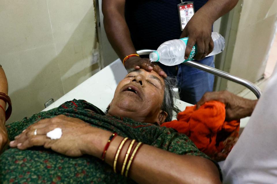 A hospital staff member pours water on the face of a patient suffering from heat stroke at a government hospital during a severe heatwave in Varanasi (AFP via Getty Images)