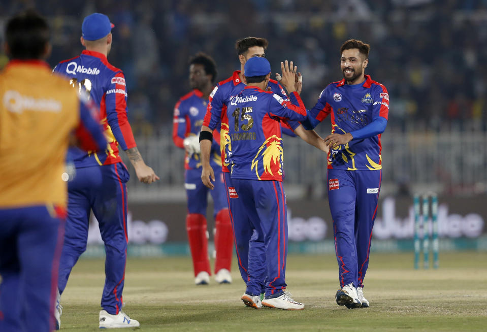 Karachi Kings pacer Mohammad Amir, right, celebrates with teammates after taking the wicket of Peshawar Zalmi batsman Lewis Gregory during the Pakistan Super League T20 cricket match in Rawalpindi, Pakistan, Monday, March 2, 2020. (AP Photo/Anjum Naveed)