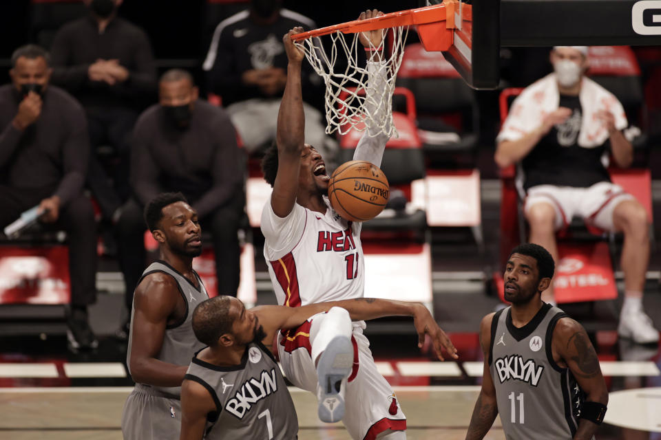 Miami Heat center Bam Adebayo dunks over Brooklyn Nets forward Kevin Durant (7) and guard Kyrie Irving (11) during the first half of an NBA basketball game Monday, Jan. 25, 2021, in New York. (AP Photo/Adam Hunger)