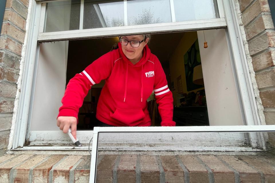 Destra Stettler with Fish Window Cleaning uses a brush to scrub dirt from a window sill at Children in Crisis' Children's Neighborhood foster family home. The company's team visited the Children's Neighborhood on Thursday to clean windows in celebration of Random Act of Kindness Day.