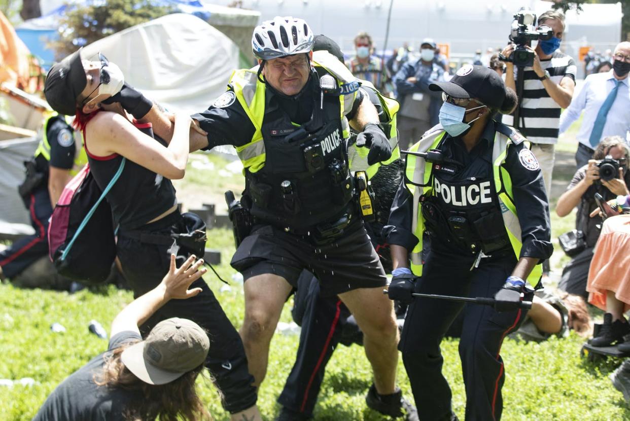 <span class="caption">Police remove encampment supporters as they clear Lamport Stadium Park encampment in Toronto on July 21, 2021.</span> <span class="attribution"><span class="source">THE CANADIAN PRESS/Chris Young </span></span>