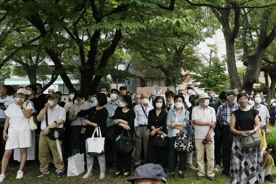 Bystanders gather at a park across from Zojoji temple before the funeral of former Japanese Prime Minister Shinzo Abe in Tokyo on Tuesday, July 12, 2022. Abe was assassinated Friday while campaigning in Nara, western Japan. (AP Photo/Hiro Komae)