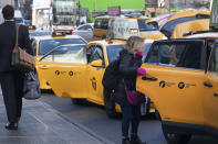 A passenger gets into a taxi, Wednesday, Jan. 29, 2020, in New York. A task force studying New York City's struggling taxi industry called Friday for “mission-driven” investors to help bail out drivers who incurred massive debt once the value of the medallion that allows a person to operate a yellow cab plummeted in the age of Uber and Lyft. (AP Photo/Mark Lennihan)