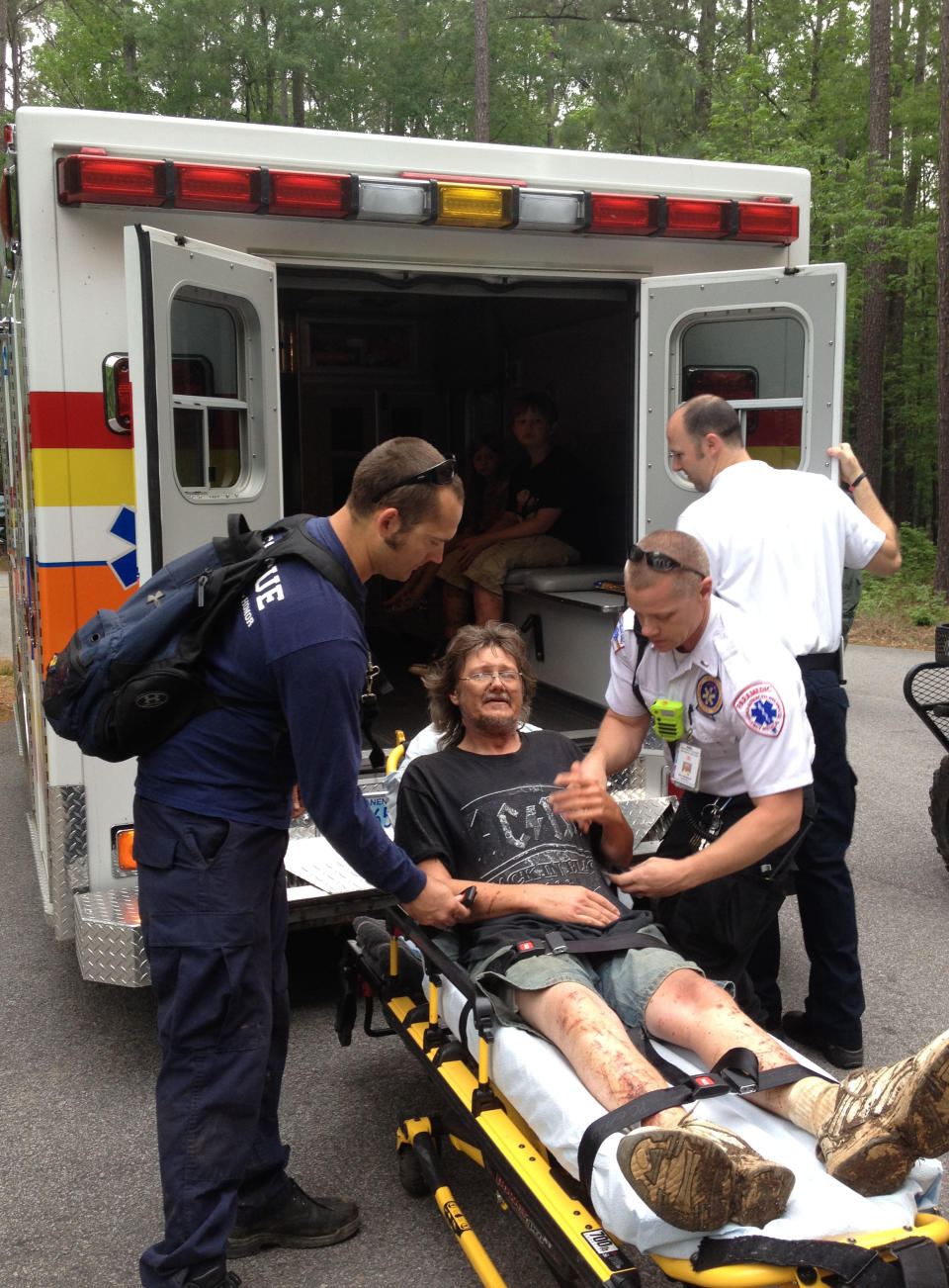 In this photo made available by the National Park Service, JR Kimber receives medical assistance at Congaree National Park in Hopkins, S.C., Tuesday, April 29, 2014. Kimber and his two children were lost in the park for two days. They were rescued and are all in stable condition. (AP Photo/National Park Service)