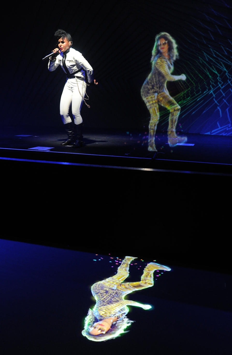 CORRECTS NAME OF EVENT FROM AUDI M3 TO AUDI A3 Janelle Monae, left, performs alongside a hologram of M.I.A. during a launch party for the Audi A3 on Thursday, April 3, 2014 in West Hollywood, Calif. (Photo by Chris Pizzello/Invision/AP)
