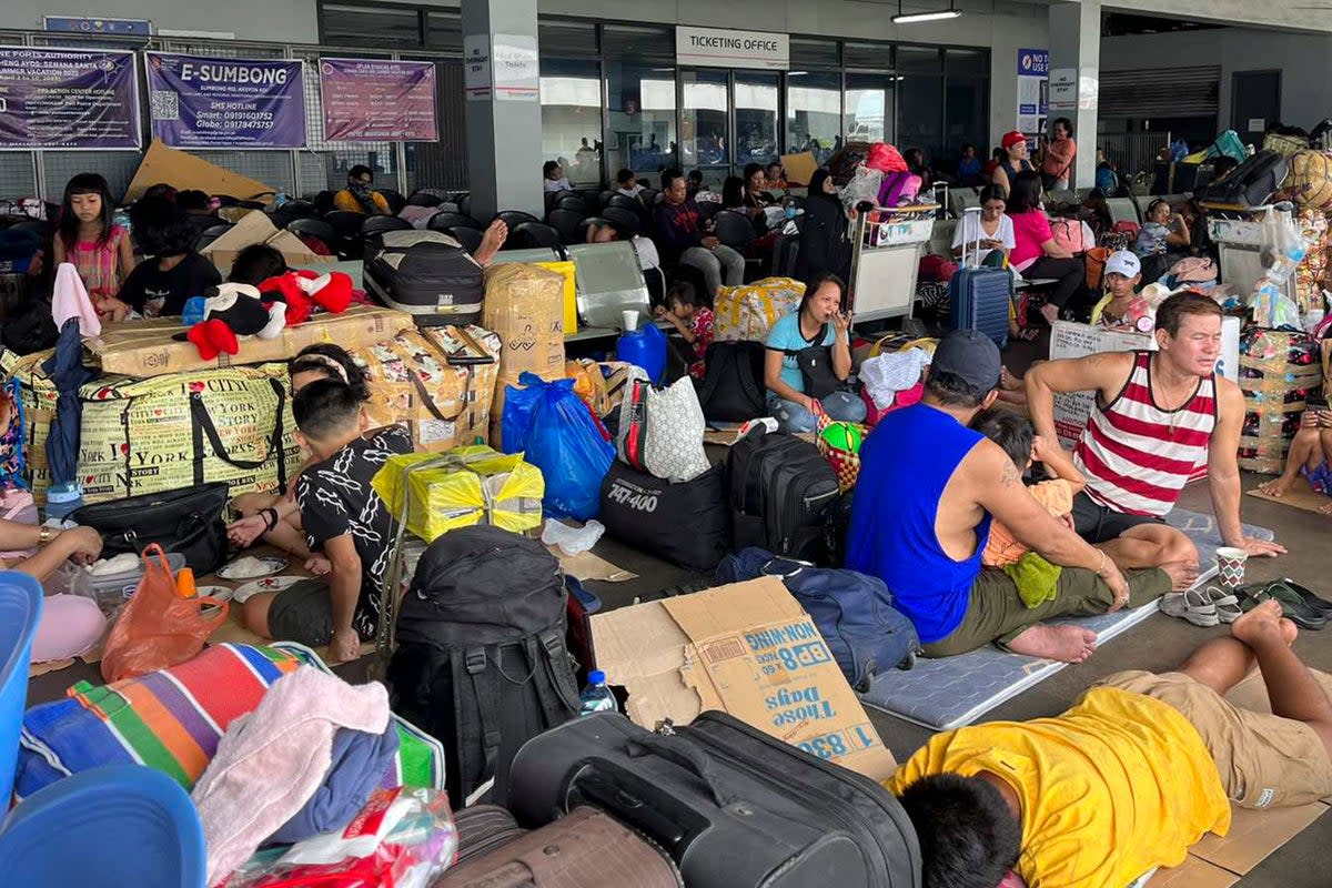In this photo provided by the Philippine Coast Guard, stranded passengers stay at a passenger terminal after sea travel was suspended due to Typhoon Doksuri in Manila, Philippines (AP)