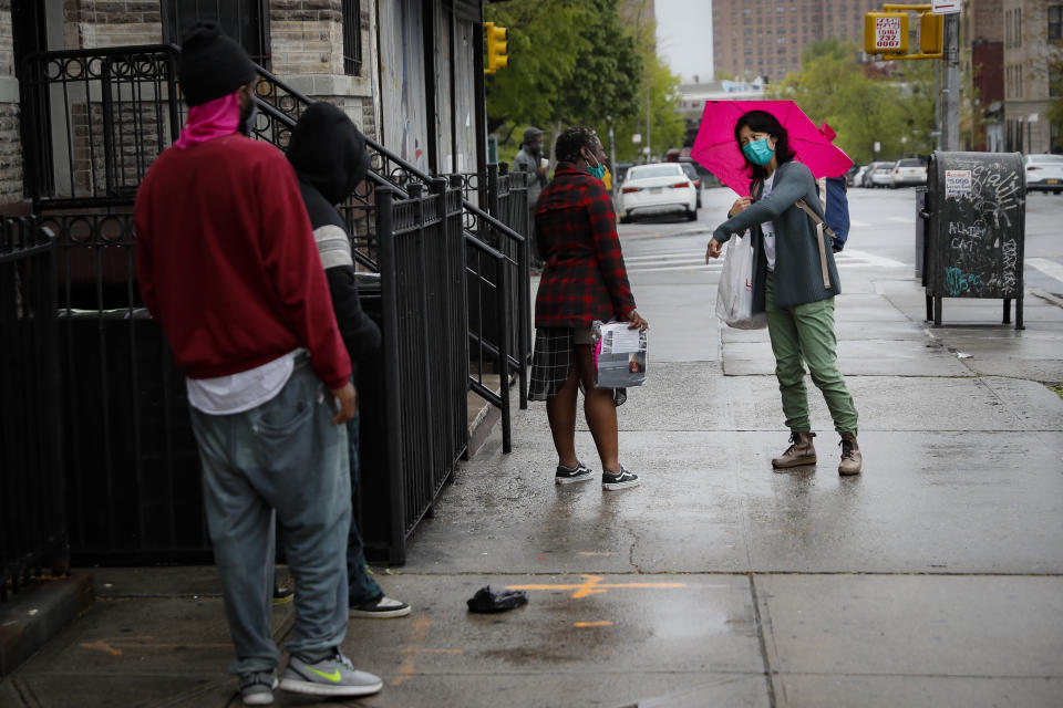 Dr. Jeanie Tse, chief medical officer at the Institute for Community Living, right, speaks with her patient Lashawn who lives with schizophrenia on the sidewalk outside The Robert Meineker House on her rounds, Wednesday, May 6, 2020, in the Brooklyn borough of New York. (AP Photo/John Minchillo)