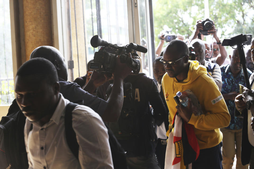 Pastor and activist Evan Mawarire, right, arrives at the magistrates courts in Harare, Zimbabwe, Thursday, Jan,17, 2019. A Zimbabwe Lawyers for Human Rights says in a statement that Mawarire who is among the more than 600 people arrested this week has been charged with subverting a constitutional government amid a crackdown on protests against a dramatic fuel price increase.(AP Photo/Tsvangirayi Mukwazhi)