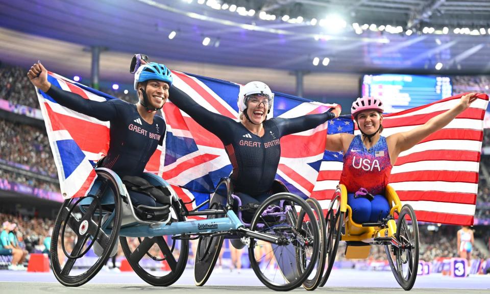 <span>Hannah Cockroft (centre) celebrates her victory in the women’s 800m T34 alongside compatriot and silver medallist Kare Adenegan.</span><span>Photograph: Marco Mantovani/Getty Images</span>