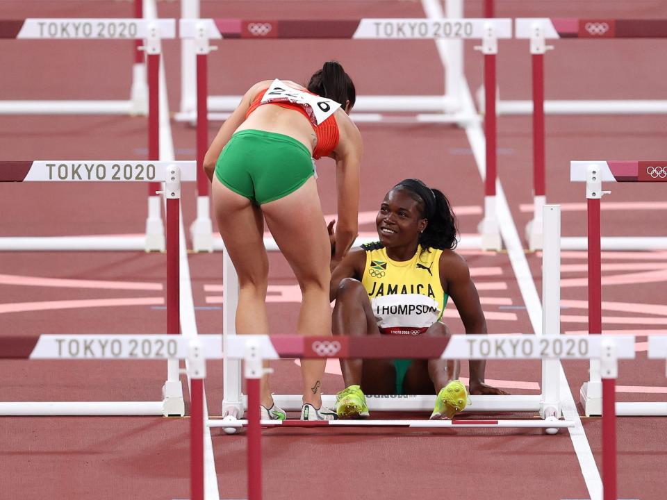 Hungary's Luca Kozak helps Jamaica's Yunique Thompson to her feet.