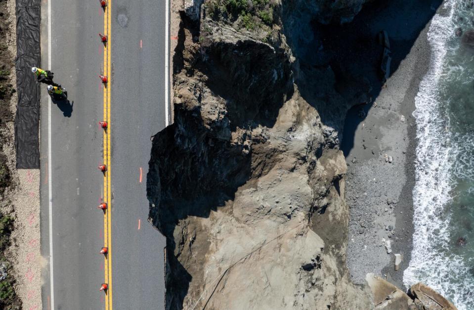 An overhead shot of a damaged road along a cliff.