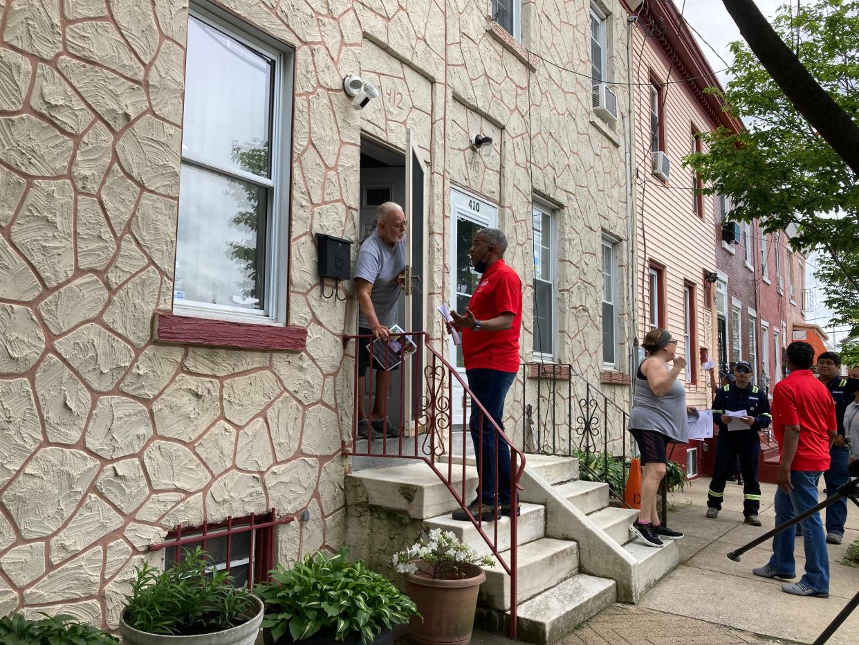 Carlos Colon talks to Mayor Vic Carstarphen as city workers fanned out in Lanning Square to talk about assistance for seniors and disabled residents.