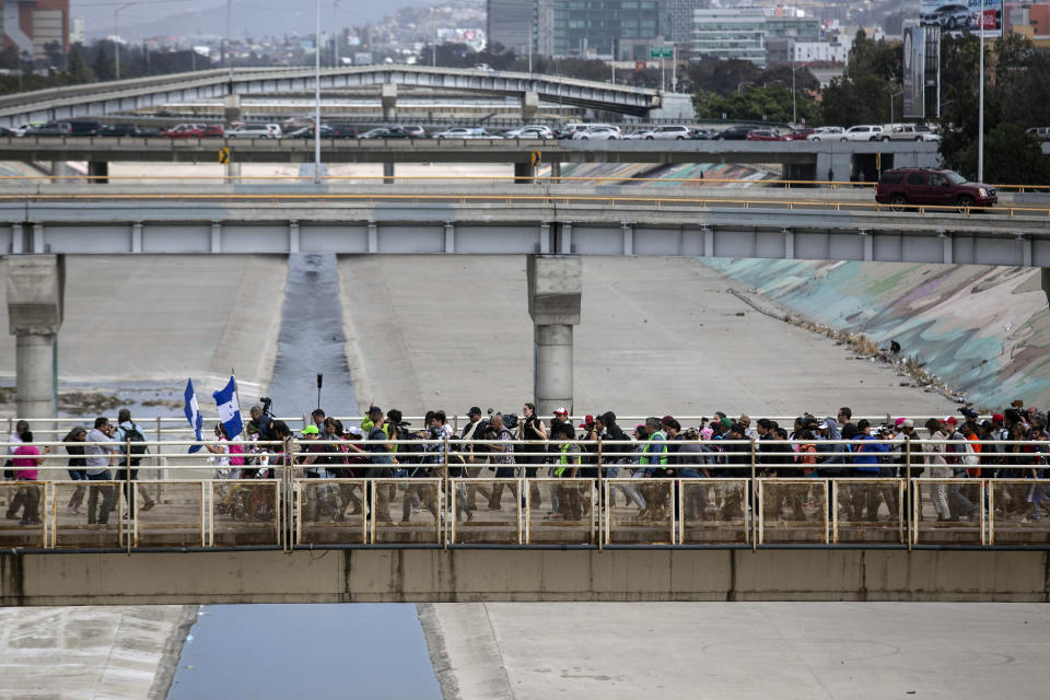 Central American migrants walk to El Chaparral border crossing.