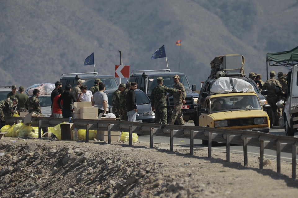 FILE - Ethnic Armenians from Nagorno-Karabakh and European Union observers drive their cars past a check point on the road from Nagorno-Karabakh to Armenia's Goris in Syunik region, Armenia, Friday, Sept. 29, 2023. Lawyers for Azerbaijan on Monday urged the top United Nations court to throw out a case filed by Armenia linked to the long-running dispute over the Nagorno-Karabakh region, arguing that judges do not have jurisdiction. (AP Photo/Vasily Krestyaninov, File)