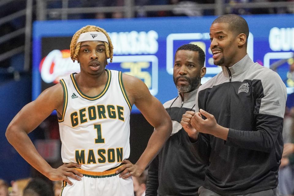 George Mason head coach Kim English talks with guard Ronald Polite III during a timeout in a game against the Kansas Jayhawks in 2022.