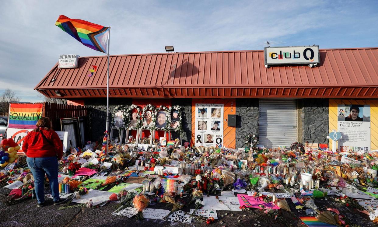 <span>A person looks on at the flowers and mementos left at a memorial at Club Q in Colorado Springs, Colorado, on 26 November 2022. </span><span>Photograph: Isaiah Downing/Reuters</span>