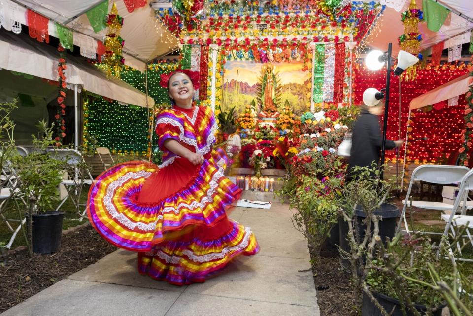 A child dances in front of an altar as part of celebration of the Virgen de Guadalupe