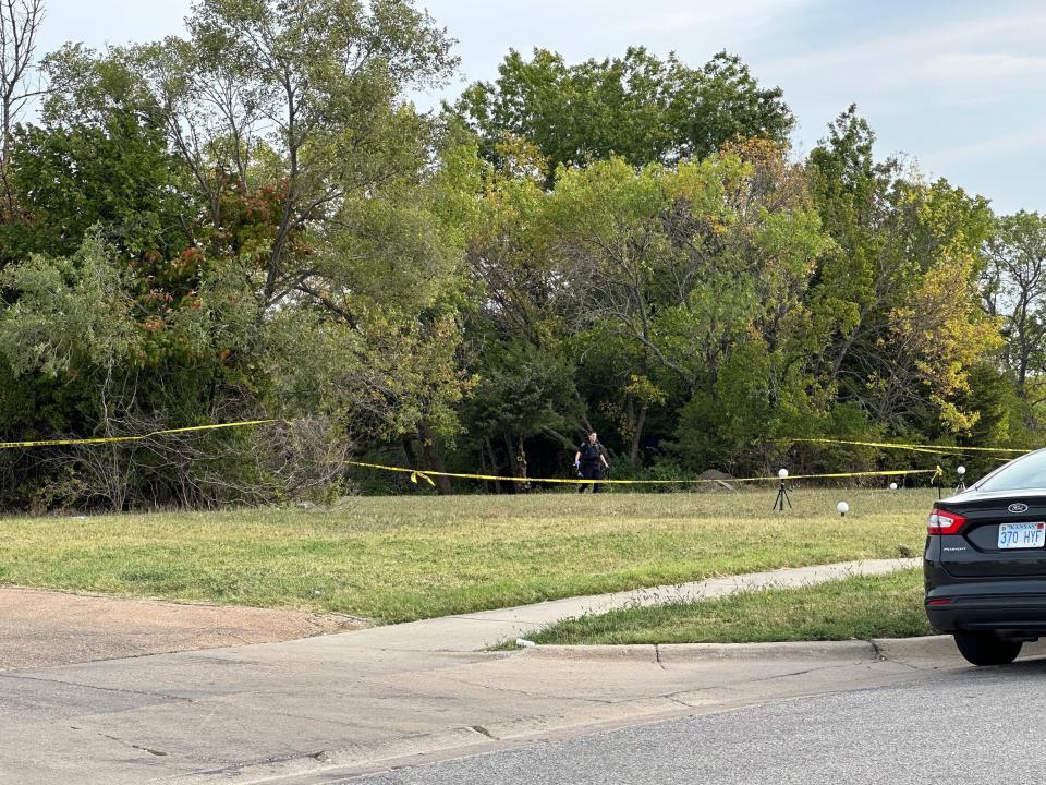 Topeka police officers walk through an area of land lined with crime scene tape next to Capital City Transportation, 2018 S.E. 28th St. A Topeka man is being held in connection with with rape and first-degree murder of a child, 5.