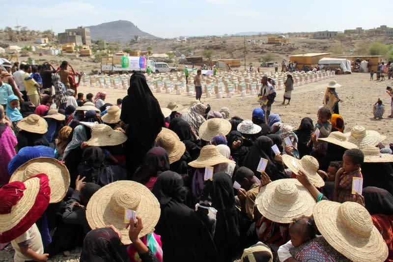 FILE PHOTO: Internally displaced people wait for food aid to be distributed by a charity in Taiz