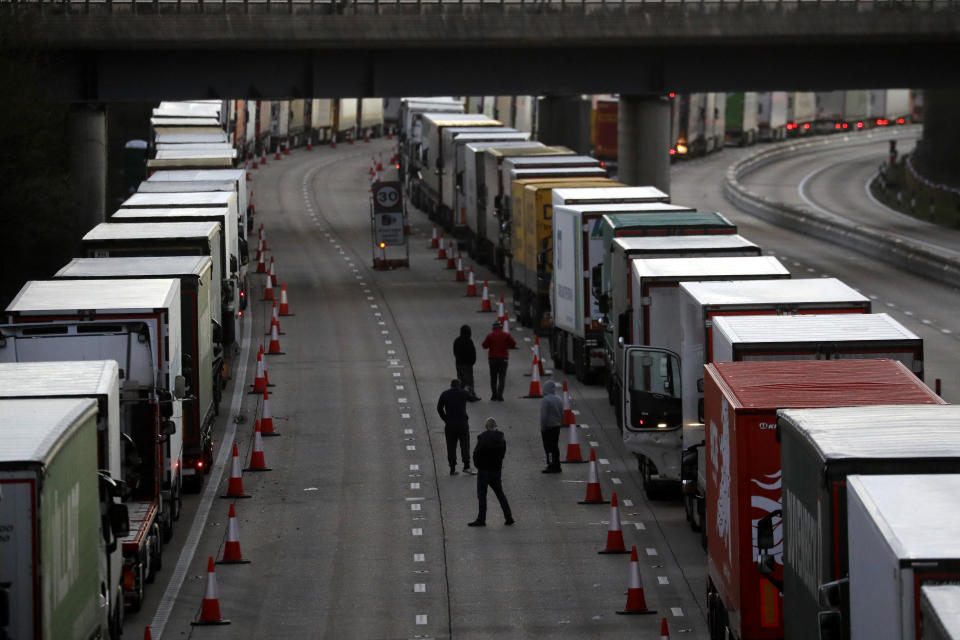 Drivers walk on the motorway as their trucks are parked up on the M20, as more arrive to join the queue, part of Operation Stack in Ashford, Kent, England, Friday, Dec. 25, 2020. Thousands wait to resume their journey across The Channel after the borders with France reopened. Trucks inched slowly past checkpoints in Dover and headed across the Channel to Calais on Thursday after France partially reopened its borders following a scare over a rapidly spreading new virus variant. (AP Photo/Kirsty Wigglesworth)