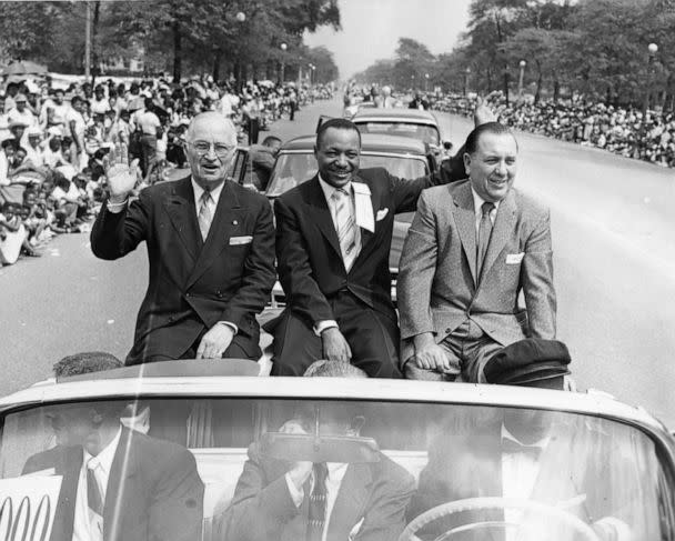 PHOTO: Former president Harry Truman, Chicago Defender publisher John H. Sengstacke, and Chicago mayor Richard J. Daley, wave to the crowd as they ride on a convertible at the Bud Billiken parade, in Chicago, in 1956.  (Robert Abbott Sengstacke/The Abbott Sengstacke Family Papers via Getty Images)