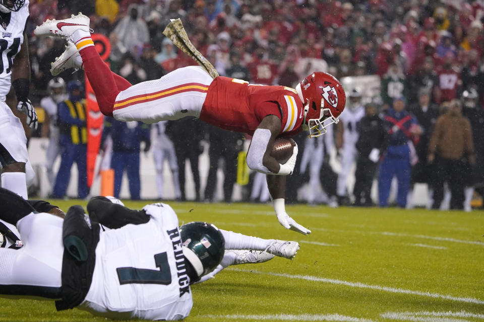 Kansas City Chiefs running back Jerick McKinnon, top, gains yardage as Philadelphia Eagles linebacker Haason Reddick (7) watches during the first half of an NFL football game Monday, Nov. 20, 2023, in Kansas City, Mo. (AP Photo/Ed Zurga)