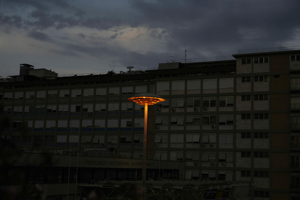 A lit lamp pole stands outside the Agostino Gemelli hospital where Pope Francis was hospitalized for intestinal surgery in Rome, Thursday, July 8 2021. The Vatican's daily update on Thursday said Francis was continuing to eat and move around unassisted, and had even sent his greetings to young cancer patients at Rome's Gemelli hospital. (AP Photo/Gregorio Borgia)
