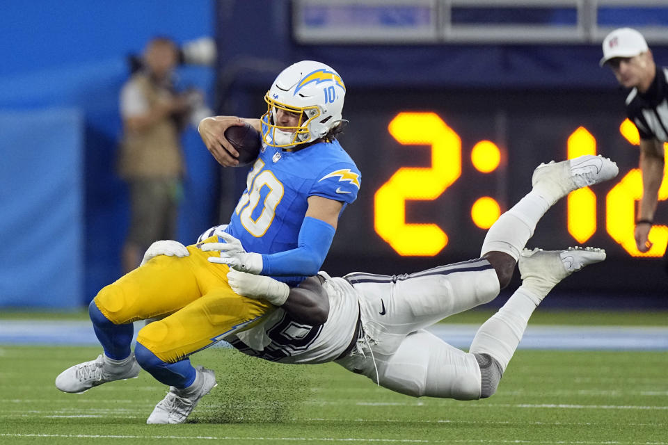 Los Angeles Chargers quarterback Justin Herbert (10) is tackled by Dallas Cowboys defensive end DeMarcus Lawrence (90) during the fourth quarter of an NFL football game Monday, Oct. 16, 2023, in Inglewood, Calif. (AP Photo/Mark J. Terrill)