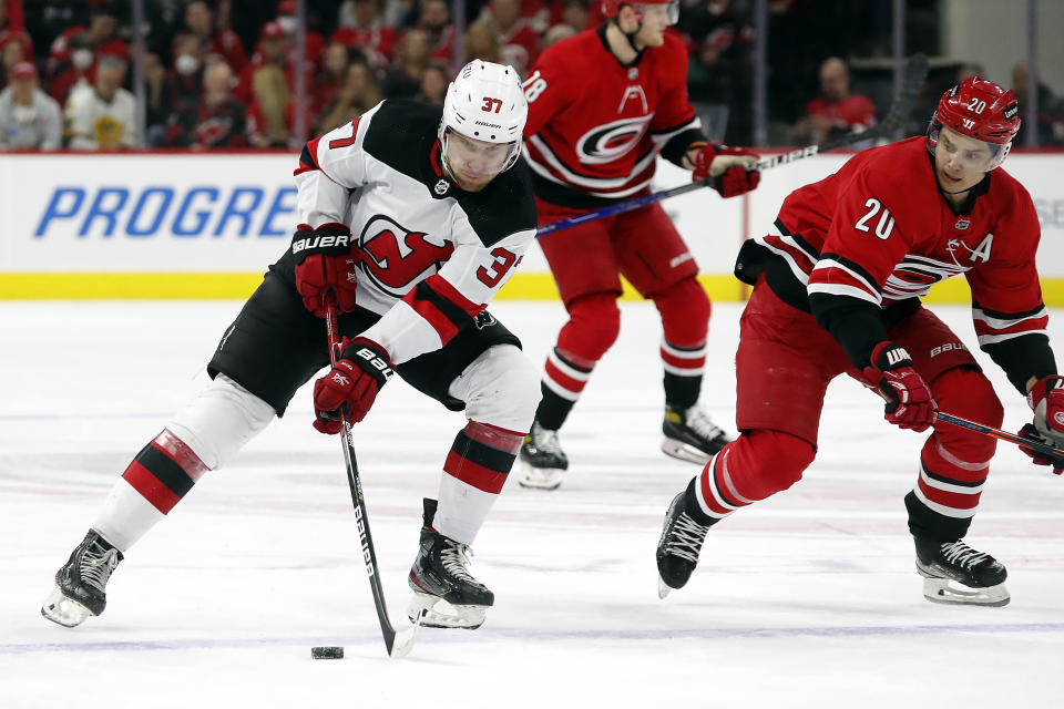 New Jersey Devils' Pavel Zacha (37) controls the puck near Carolina Hurricanes' Sebastian Aho (20) during the first period of an NHL hockey game in Raleigh, N.C., Thursday, April 28, 2022. (AP Photo/Karl B DeBlaker)