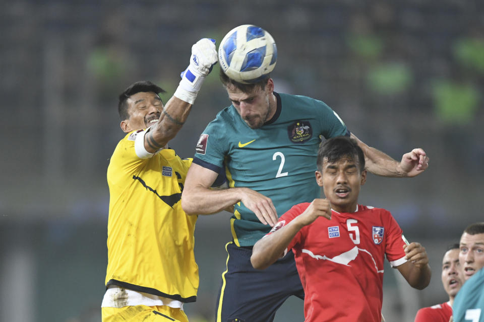 Nepal's goalkeeper Kiran Limbu and Australia's Milos Degenek fight for the ball during the World Cup 2022 Group B qualifying soccer match between Nepal and Australia in Kuwait City, Kuwait, Friday. June 11, 2021. (AP Photo/Jaber Abdulkhaleg)