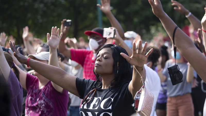 A woman prays during a OneRace March on Atlanta prayer service and march in response to recent racially violence on June 19, 2020, in Atlanta.