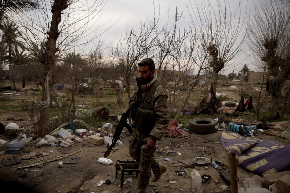 A U.S.-backed Syrian Democratic Forces (SDF) fighter walks inside a tent encampment that was occupied by Islamic State militants in Baghouz, Syria, Sunday, March 10, 2019. U.S.-backed Syrian fighters resumed their offensive on the last pocket held by the Islamic State group in eastern Syria on Sunday lighting the skies over the besieged village as artillery shelling and heavy gunfire rang in the distance. (AP Photo/Maya Alleruzzo)