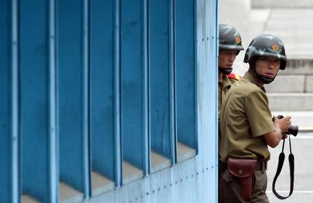 North Korean soldiers watch the south side as the United Nations Command officials visit after a commemorative ceremony for the 64th anniversary of the Korean armistice at the truce village of Panmunjom in the Demilitarized Zone (DMZ) dividing the two Koreas July 27, 2017. REUTERS/Jung Yeon-Je/Pool