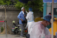 A resident gets swabbed during mass COVID-19 test on Monday, May 9, 2022, in Beijing. (AP Photo/Ng Han Guan)