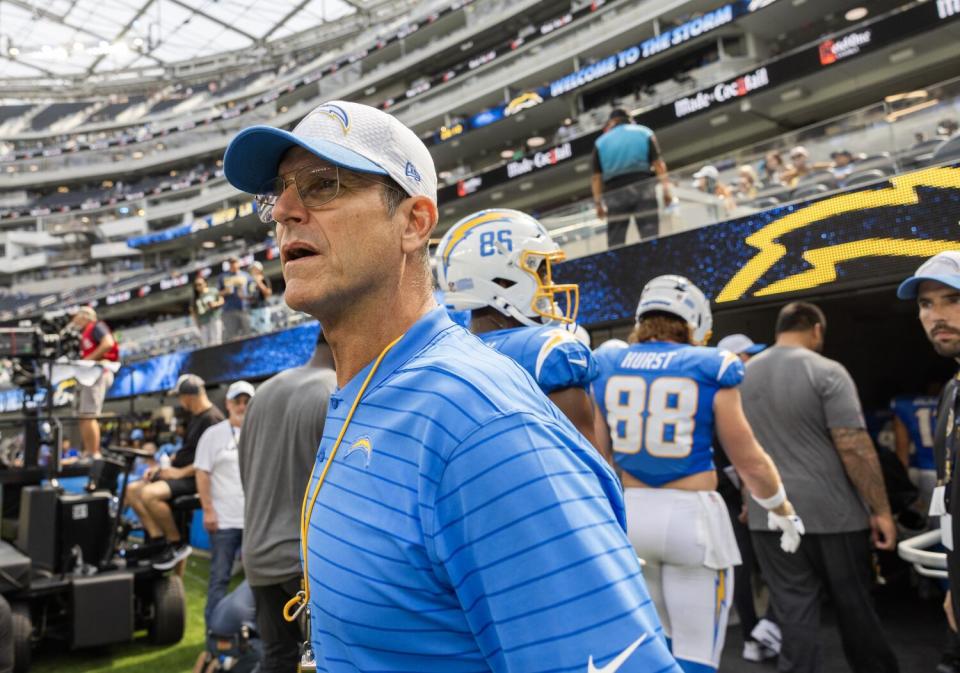 Chargers coach Jim Harbaugh looks around SoFi Stadium before a preseason game.