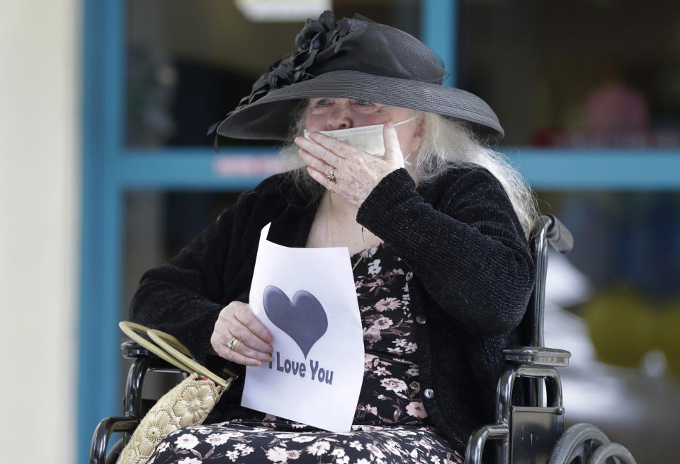 FILE - In this July 17, 2020, file photo, Margaret Choinacki, 87, who has no other family members left because her husband and daughter have died, blows kisses to her friend Frances Reaves during a drive-by visit at Miami Jewish Health in Miami. Floridians will soon be allowed to visit loved ones in nursing homes after nearly six months of vulnerable seniors being cut off from family as Gov. Ron DeSantis announced Tuesday, Sept. 1, 2020, that facilities could start a partial reopening. (AP Photo/Wilfredo Lee, File)