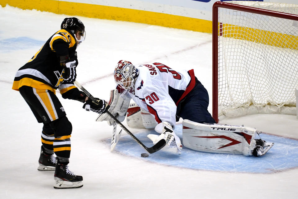 Pittsburgh Penguins' Jake Guentzel, left, puts a shot under the glove hand of Washington Capitals goaltender Ilya Samsonov (30) for a goal during a shootout in an NHL hockey game in Pittsburgh, Sunday, Jan. 17, 2021. (AP Photo/Gene J. Puskar)