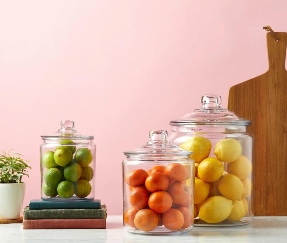 three glass jars with citrus fruits in them