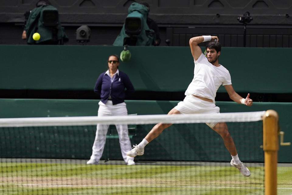 Carlos Alcaraz devuelve ante Novak Djokovic durante la final masculina de Wimbledon, el domingo 16 de julio de 2023, en Londres. (AP Foto/Alberto Pezzali)