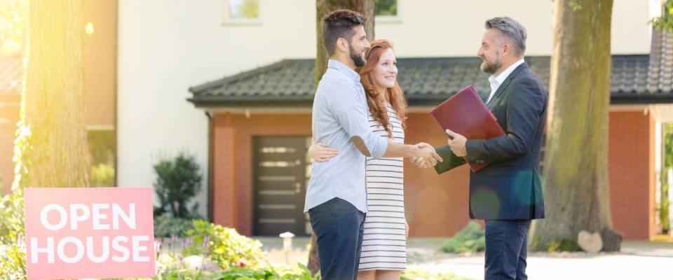 Real estate agent welcoming young visitors coming to open house