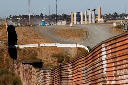 FILE PHOTO - Prototypes (R) for U.S. President Donald Trump's border wall with Mexico are shown near completion behind the current border fence, in this picture taken from the Mexican side of the border, in Tijuana, Mexico, October 23, 2017. REUTERS/Jorge Duenes