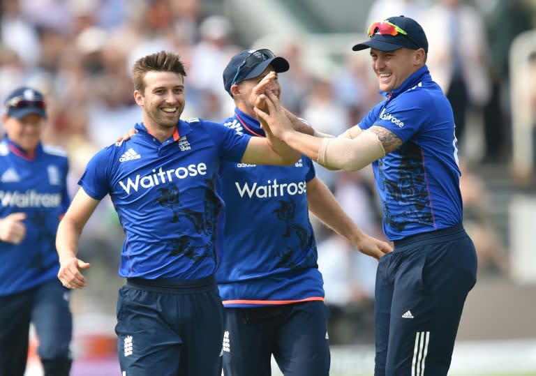 England's Mark Wood (L) celebrates with Joe Root and Jason Roy (R) after taking the wicket of Pakistan's Shoaib Malik during the second one day international cricket match between England and Pakistan at Lord's cricket ground on August 27, 2016