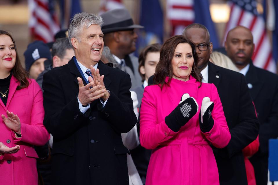 Michigan Gov. Gretchen Whitmer, right, and husband, Marc Mallory, applaud during inauguration ceremonies, Sunday, Jan. 1, 2023, outside the state Capitol in Lansing, Mich.