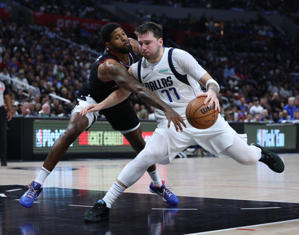 LOS ANGELES, CALIFORNIA - APRIL 23: Luka Doncic #77 of the Dallas Mavericks drives to the basket on Paul George #13 of the LA Clippers during a 96-93 Mavericks win in game two of the Western Conference First Round Playoffs at Crypto.com Arena on April 23, 2024 in Los Angeles, California. User is consenting to the terms and conditions of the Getty Images License Agreement. (Photo by Harry How/Getty Images)