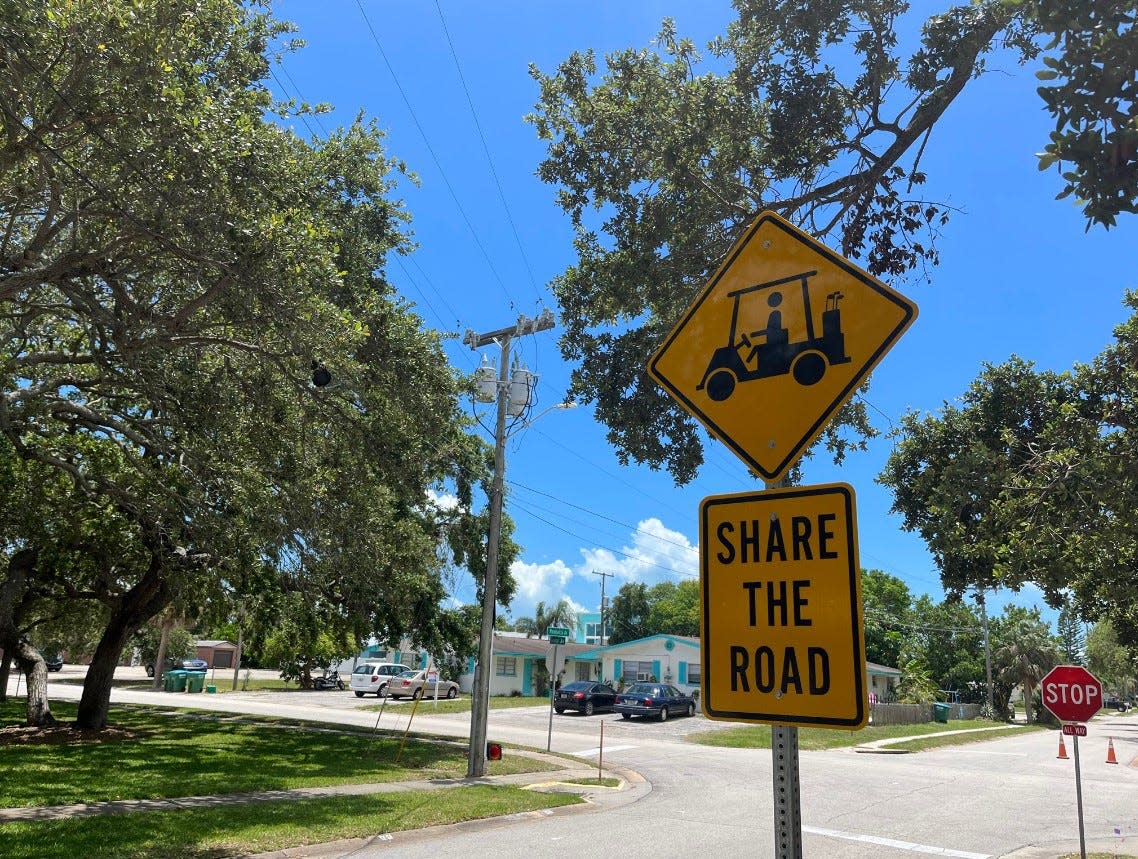 New golf cart signage indicated where golf carts are permitted. This one encourages drivers to share the road with golf carts near the Cape Canaveral library.