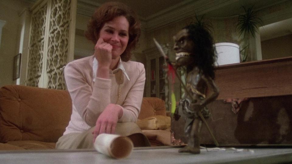 Karen Black looks bemused as she beholds a horrific Zuni warrior doll on her table in the third part of the horror TV movie, Trilogy of Terror.