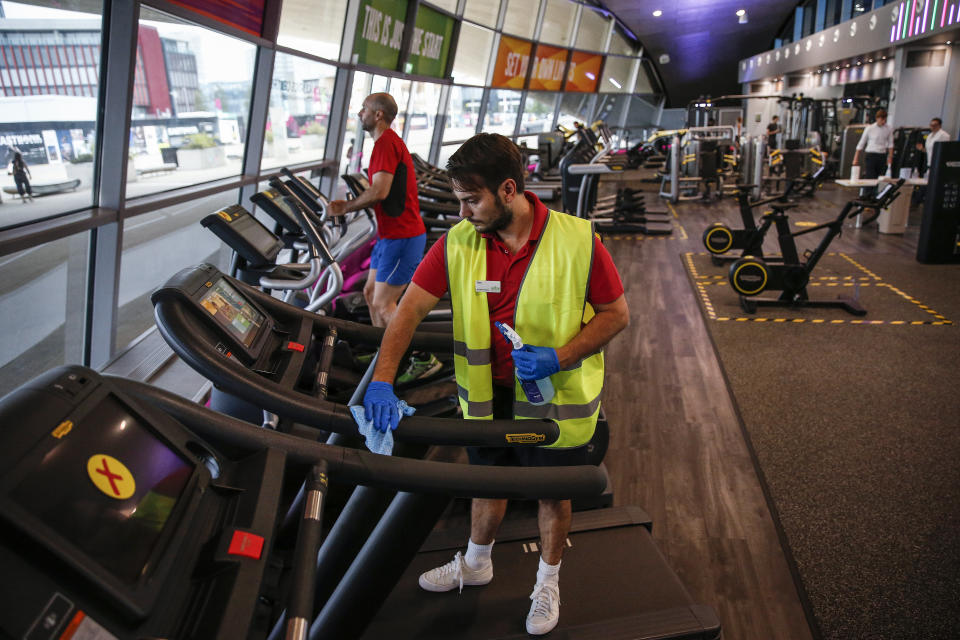 A worker disinfects a treadmill in the gym at London Aquatics Centre.