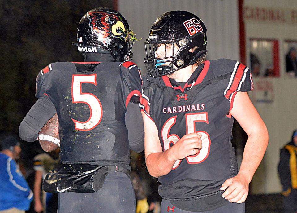 Deuel quarterback Trey Maaland (5) bumps shoulders with lineman Ethan Prins after scoring a touchdown during a high school football game against Redfield on Friday, Oct. 13, 2023 in Clear Lake. The fifth-rated Class 11B Cardinals won 50-0.