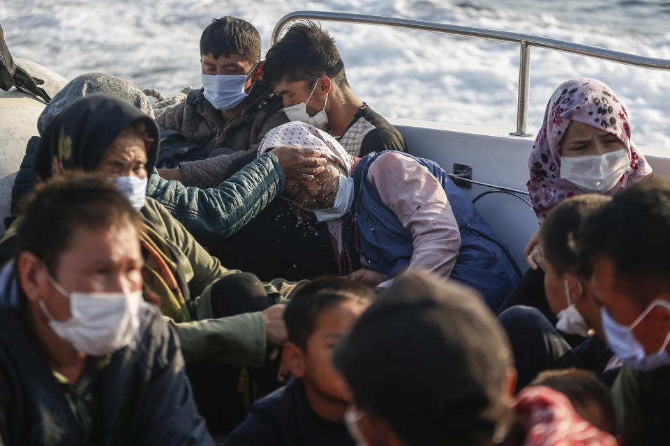 Migrants sit on a Turkish coast guard vessel after they were pulled off life rafts, during a rescue operation in the Aegean Sea, between Turkey and Greece, Saturday, Sept. 12, 2020. Turkey is accusing Greece of large-scale pushbacks at sea — summary deportations without access to asylum procedures, in violation of international law. The Turkish coast guard says it rescued over 300 migrants "pushed back by Greek elements to Turkish waters" this month alone. Greece denies the allegations and accuses Ankara of weaponizing migrants. (AP Photo/Emrah Gurel)